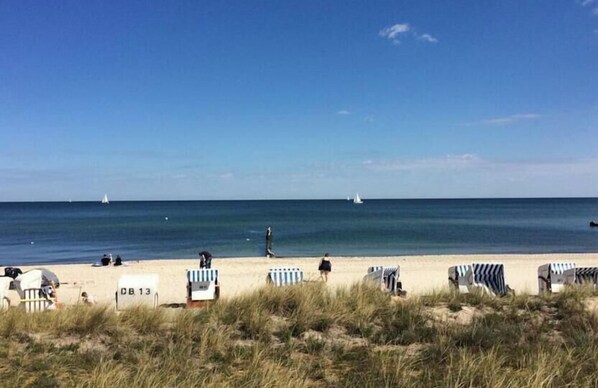 A beach with rows of striped beach chairs and a sign labeled 'DB 13'. - Apartment Residence Baltic Sea Beach (Kühlungsborn)