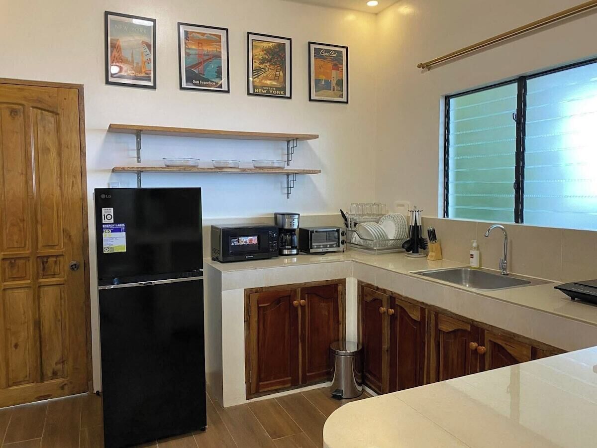 A compact kitchen with a refrigerator, microwave, toaster, and sink.