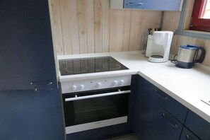 A compact kitchen with a stove, oven, and a coffee maker. - Holiday home IDA in the Mirow holiday park (Mirow-Granzow)