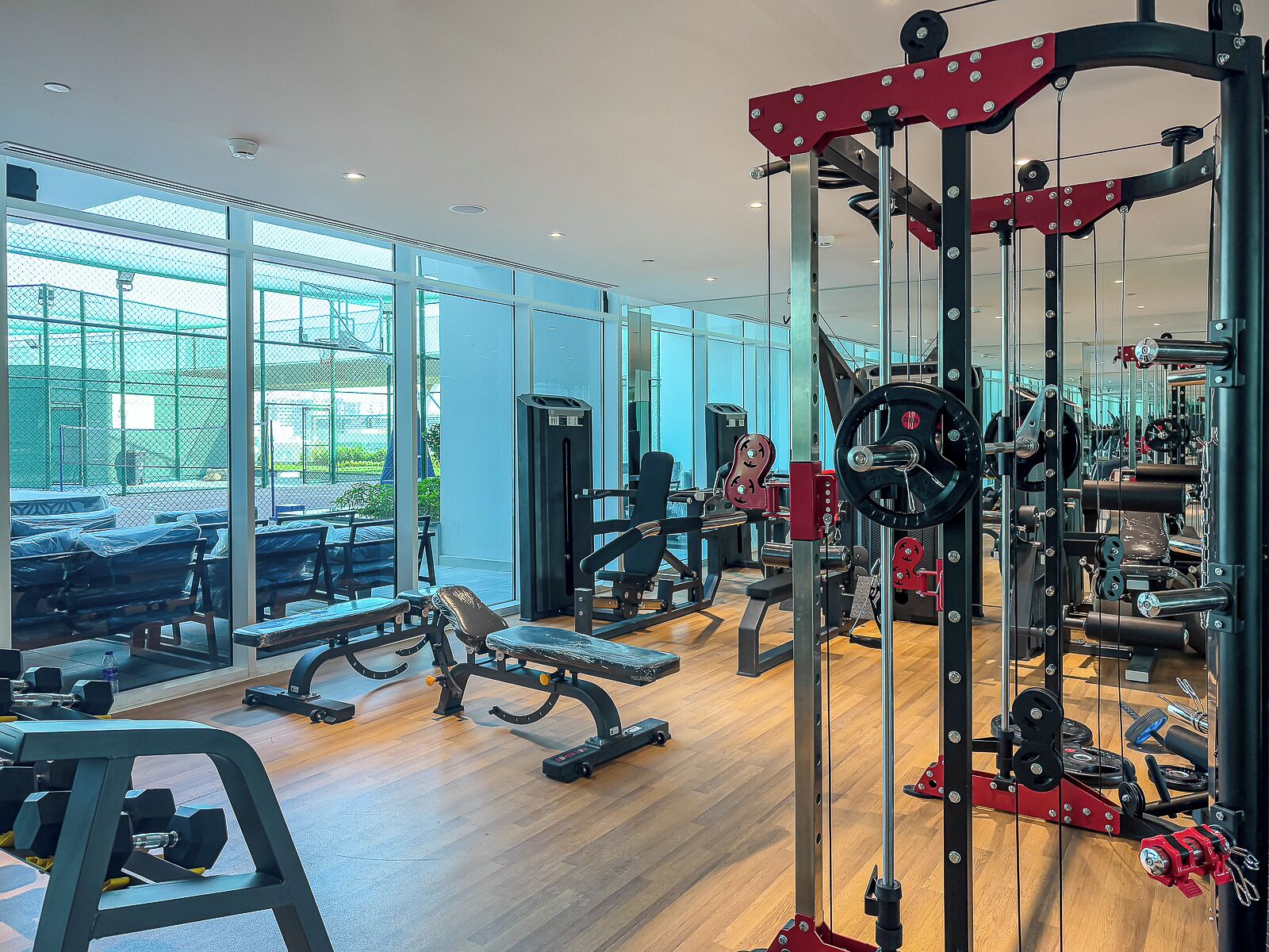 Una palestra con diverse attrezzature per esercizi, ampie finestre e vista esterna.