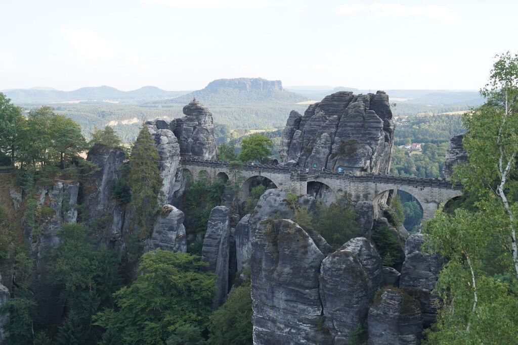 Eine Brücke mit mehreren Bögen, die ein felsiges Tal überspannt.