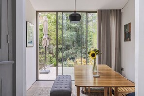 Ein stilvoller Essbereich mit Holztisch, Bank und einer Vase mit Sonnenblumen.