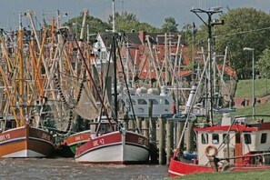 A harbor with multiple boats docked, including a red and white boat with 'GRE 42' on its side. - Holiday home with 2 bedrooms (Krummhörn)