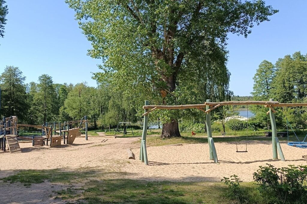 Ein Spielplatz mit Schaukeln und Klettergerüsten.