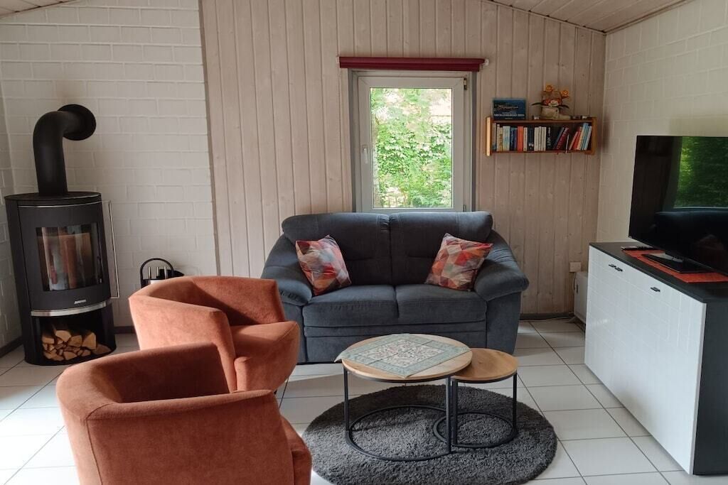 Un salon confortable avec un canapé, une petite table ronde, une cheminée et un téléviseur.