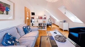 Um apartamento loft moderno com beliche, sofá listrado, estante de livros e área de refeições.