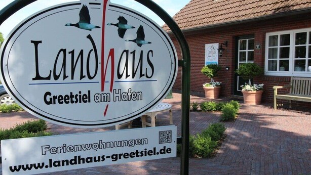 Placa de identificação do Landhaus, com endereço do site e código QR.