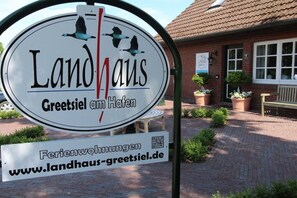 Une enseigne pour Landhaus, avec l’adresse du site web et un code QR.