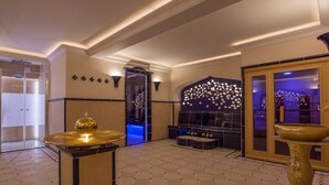 Un hall d’entrée spacieux avec un espace salon central, un mur décoratif et une grande fenêtre.