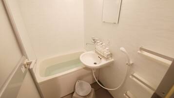 Un baño pequeño con una bañera, un lavabo e inodoro.