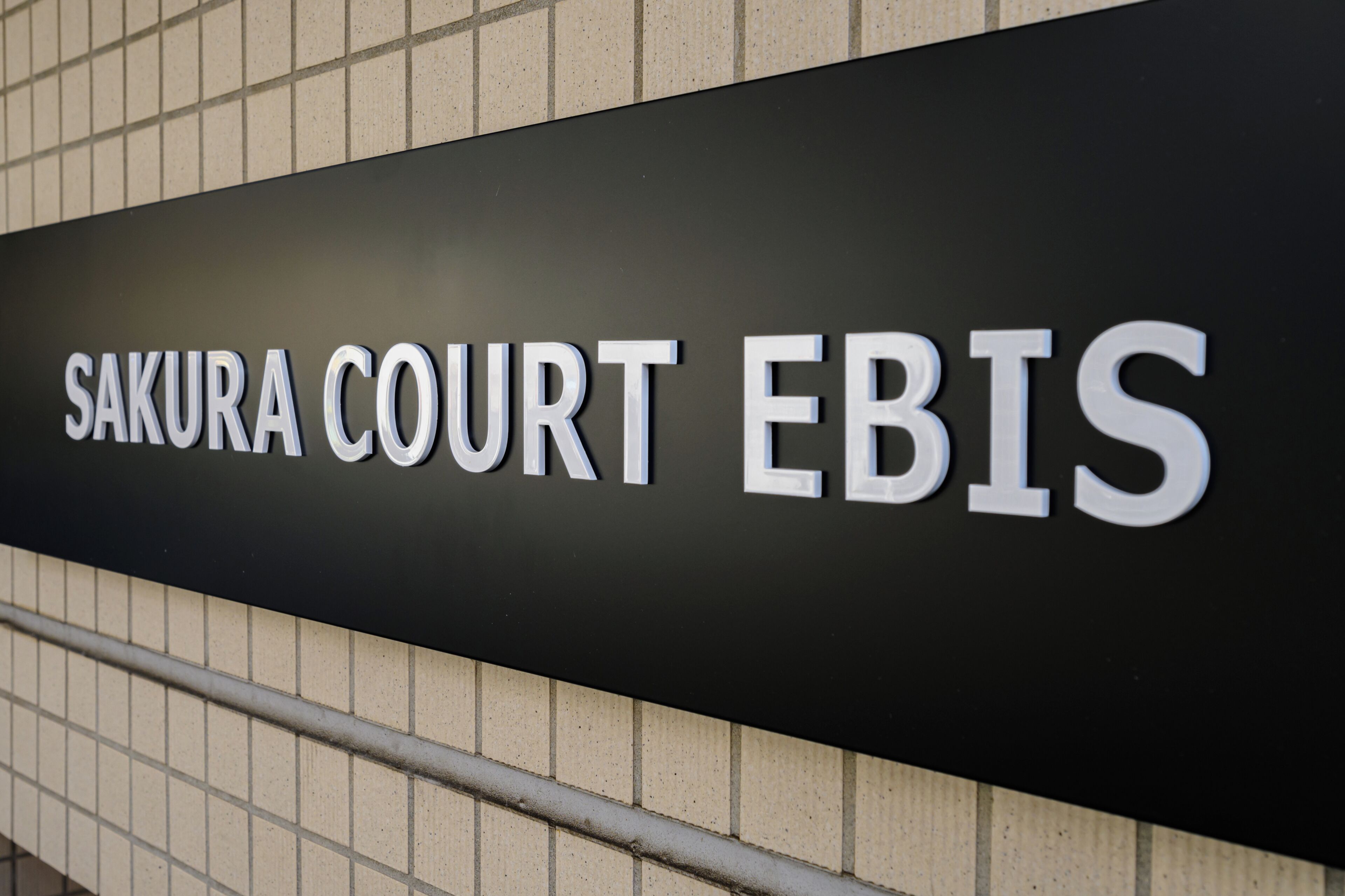 A sign for 'Sakura Court EBIS' on a building facade.