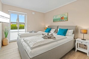 Une chambre d’hôtel avec un lit, une table de chevet, une fenêtre et un tableau au mur.
