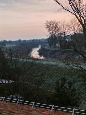 A river with a bridge in the background, surrounded by trees and vegetation. - B&B RioReno (CITTÀ METROPOLITANA DI BOLOGNA)