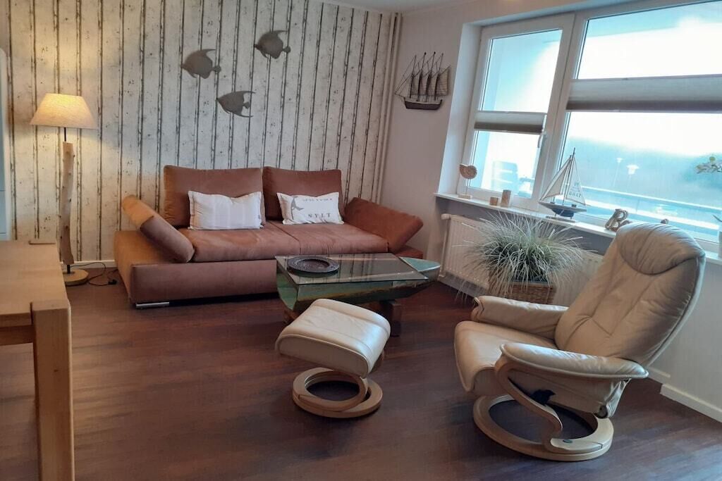 A living room with a sofa, a rocking chair, a coffee table, and a lamp.