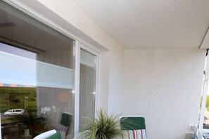 Ein Balkon mit Blick auf einen Parkplatz und ein Gebäude im Hintergrund.