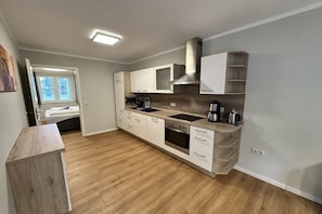 A modern kitchen with a built-in oven, sink, and cabinets. - Beach house Seeperle Apt. Seerose (Ostsee Bad Boltenhagen)