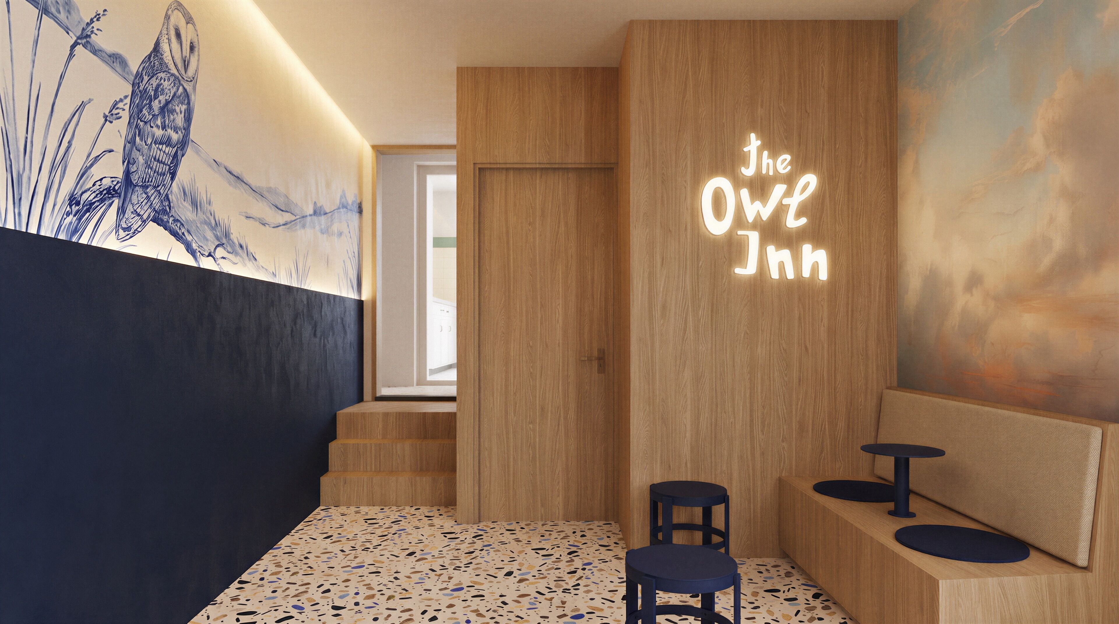Een hotellobby met een houten receptiebalie, twee zithoeken, een muurschildering en een neonbord waarop 'The Owl Inn' staat.