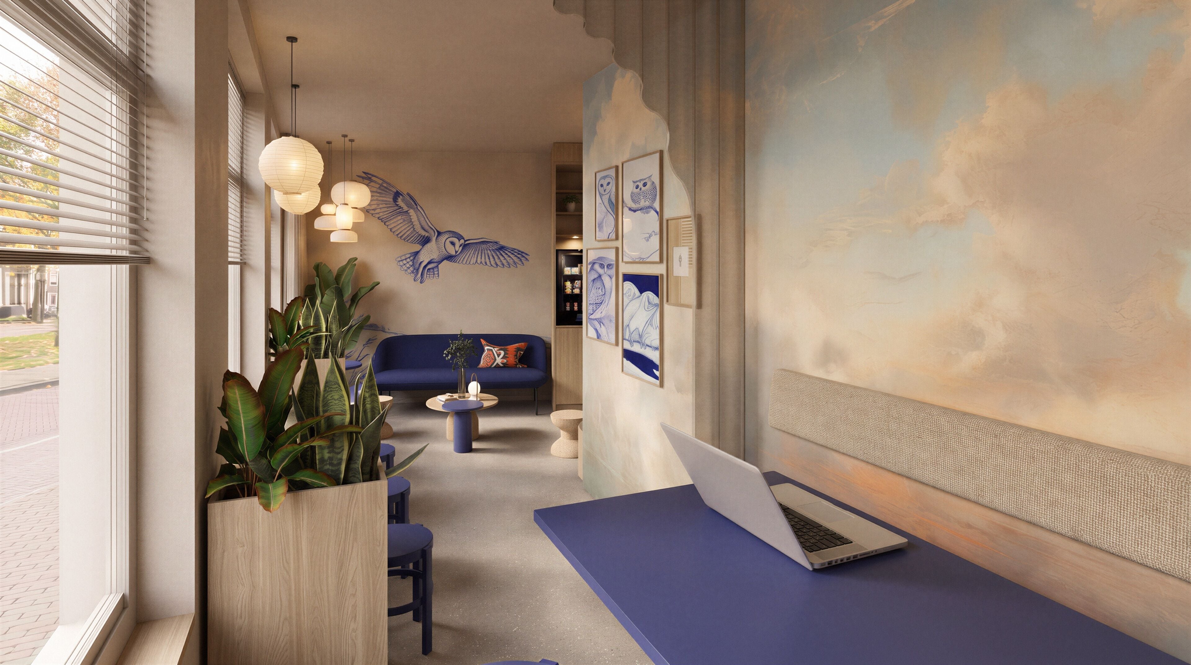 A modern interior with a blue sofa, a laptop on a desk, and a wall with artwork.