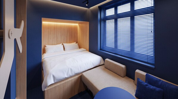 A modern bedroom with a bed, bedside tables, a bench, and a window with blinds. - The Owl Inn (Leiden)