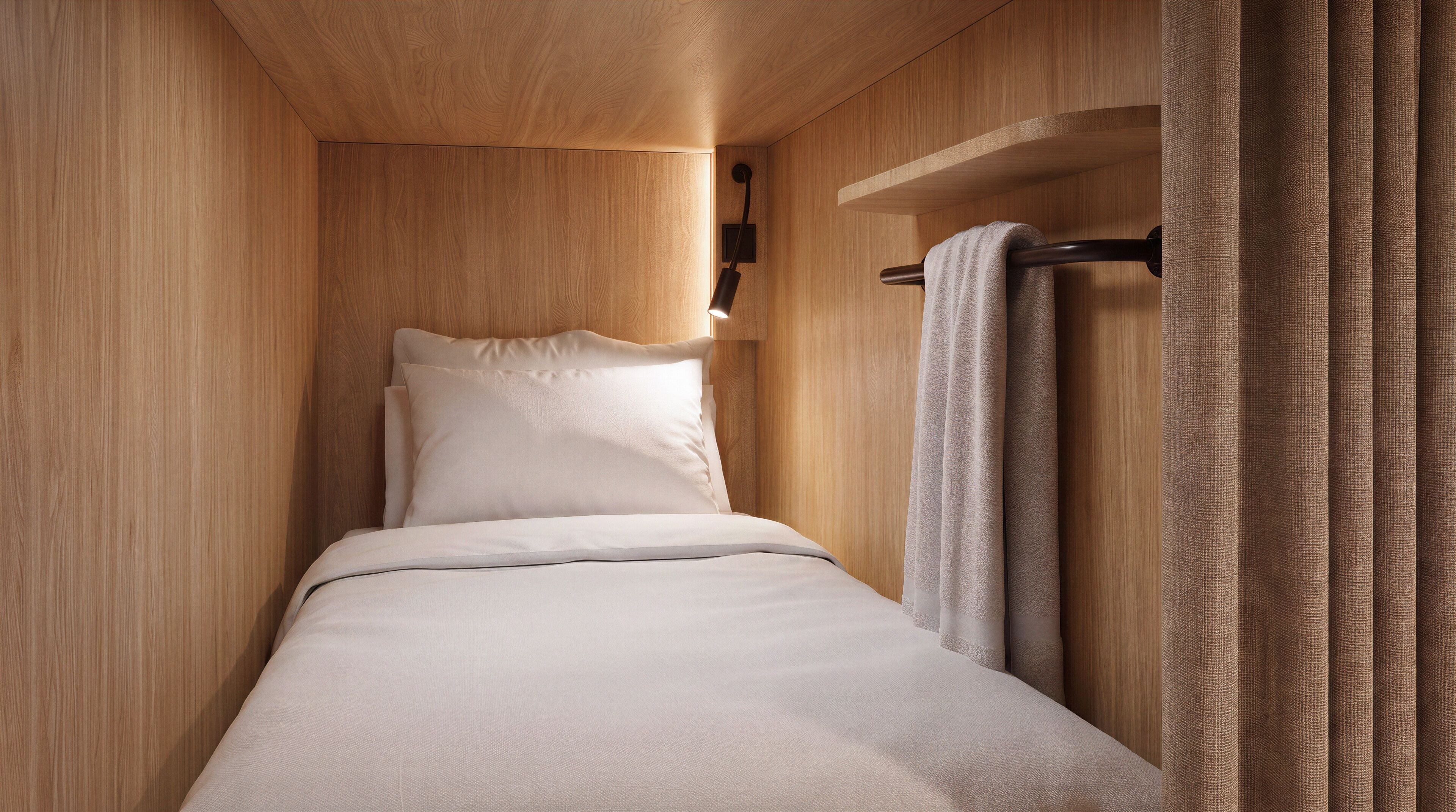 A narrow, wooden-paneled room with a single bed, a hanging light fixture, and a curtain.
