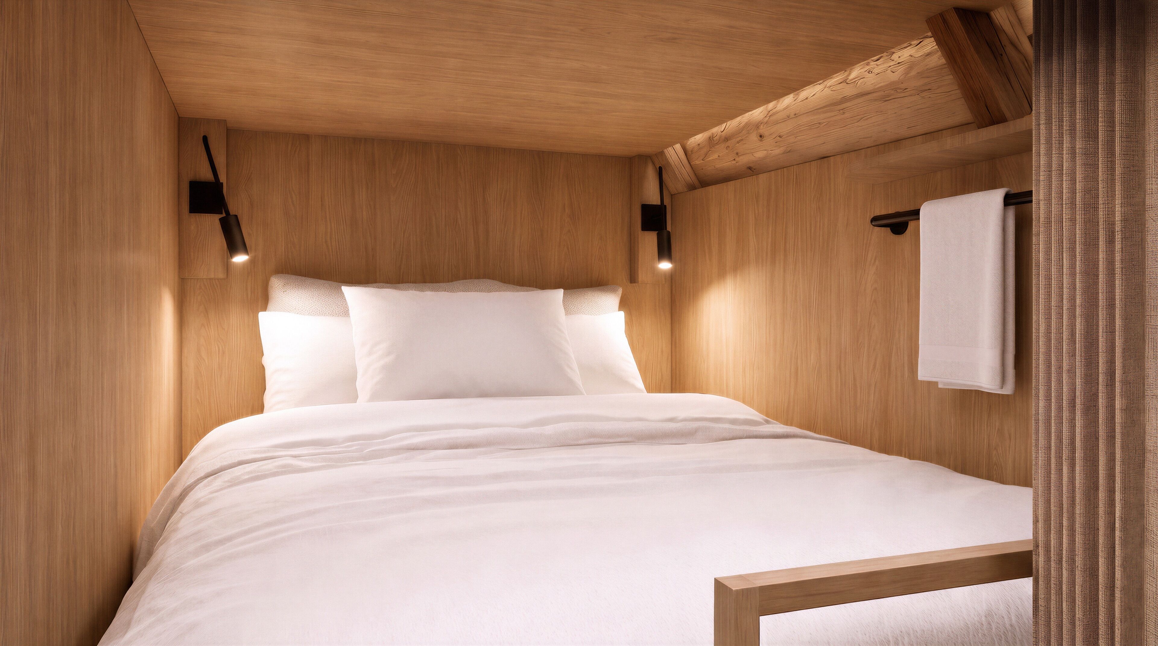 Een kamer met houten wanden, een bed, kussens, een ophangend handdoek en wandlampen.