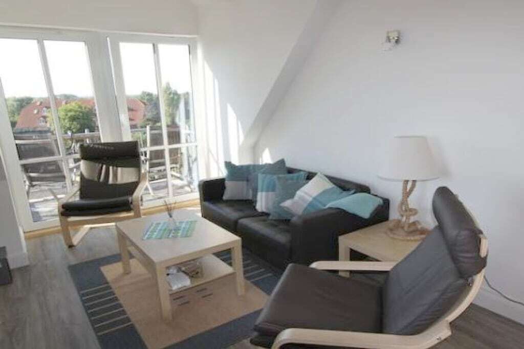 A modern living room with a sofa, armchair, and coffee table.