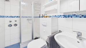 A bathroom with a shower, toilet, and sink. - Holiday apartment with 2 bedrooms (Langeoog)