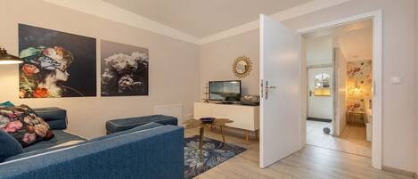 Een moderne woonkamer met een bank, een bijzettafeltje en kunst aan de muur.