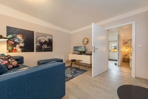 A modern living room with a sofa, a coffee table, and artwork on the wall. - Holiday apartment in Binz with swimming pool (Binz)
