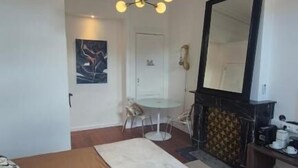 Un dormitorio con cama, candelabro, chimenea y espejo.