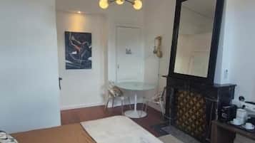 A bedroom with a bed, a chandelier, a fireplace, and a mirror.
