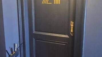 Una puerta de madera oscura con el número '7211' en dorado y una cerradura.