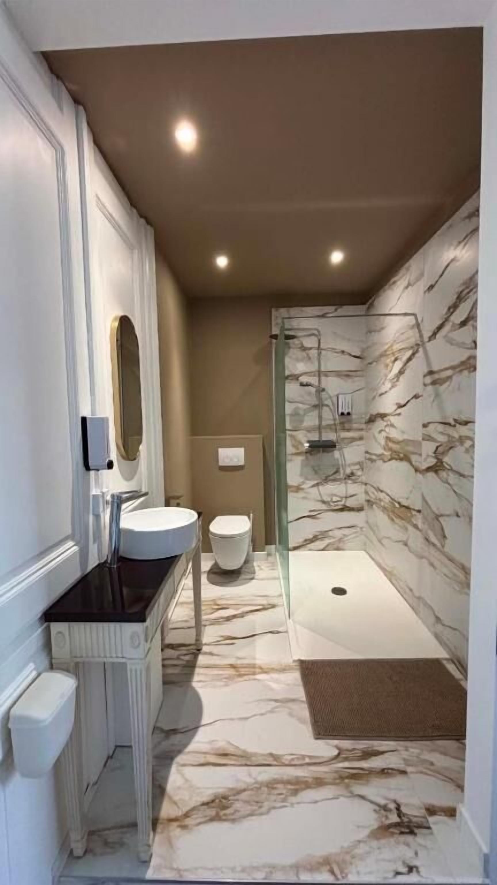 A bathroom with a marble floor, a shower, and a toilet.