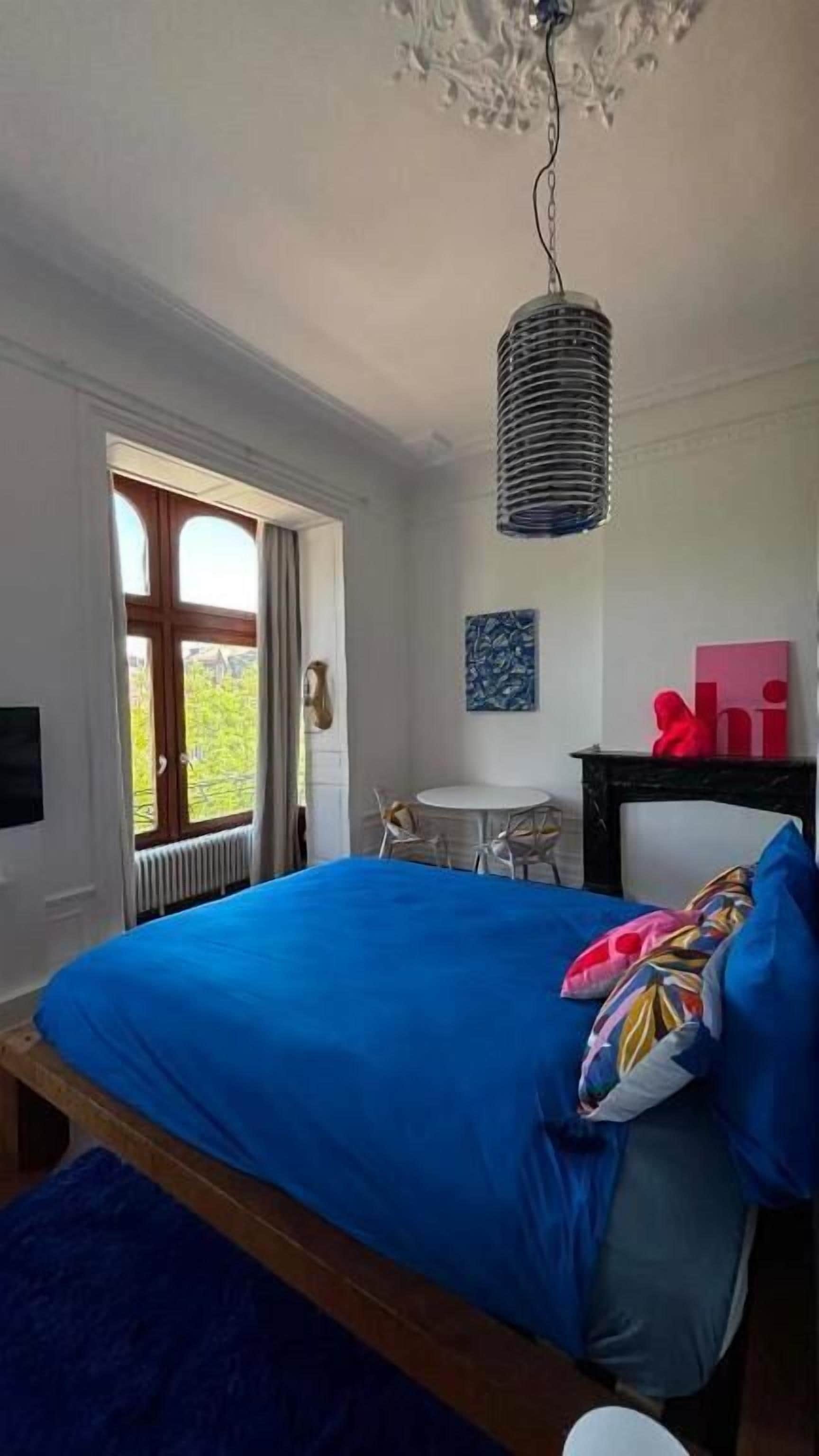 Een slaapkamer met een bed, een bureau en een stoel.