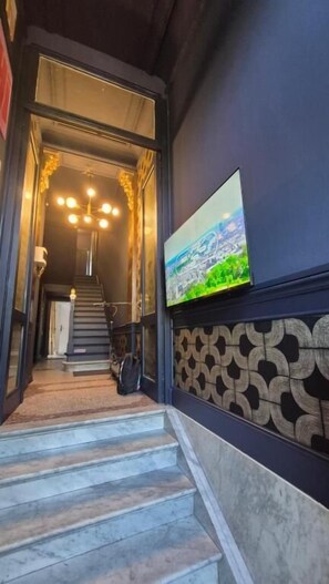 A staircase leading to a room with a patterned wall and a painting.