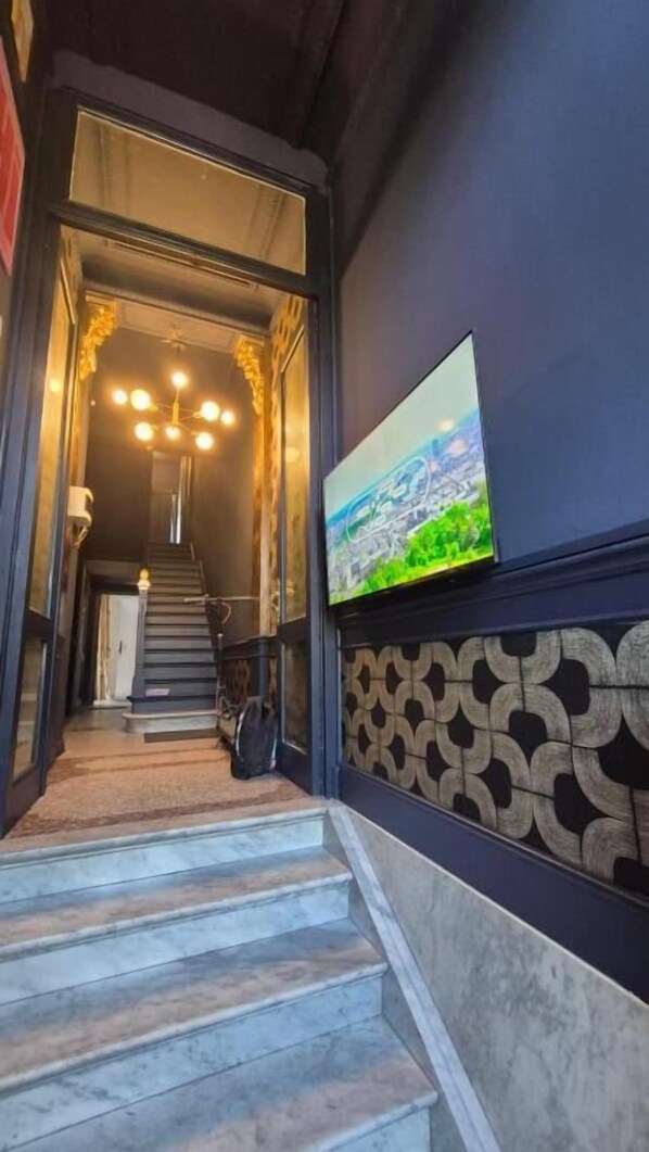 Una escalera que lleva a una habitación con un muro decorado y un cuadro.
