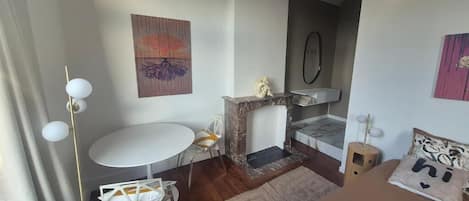 A modern room with a round table, a fireplace, and artwork on the walls.