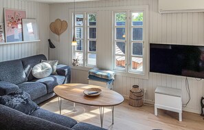 A living room with a sofa, a coffee table, a television, and a window with a view of the outside. - 3 bedroom awesome home in Tarm (Tarm)