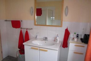 Ein Badezimmer mit Waschbecken, Spiegel und Handtuchhalter.
