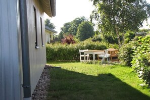 Ein Wohnhaus mit Garten und einer Holzterrasse.