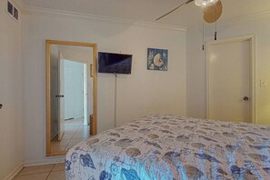 Ein Schlafzimmer mit einem Bett, einem Fernseher und einer Tür.