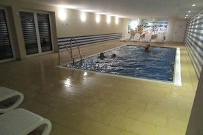 An indoor swimming pool with tiled flooring, a ladder, and lounge chairs. - House Sea View Apartment A 1.04 (Baabe)