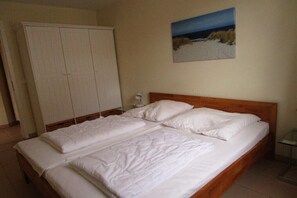 A double bed with white bedding in a room with a wooden headboard. - House Sea View Apartment A 1.04 (Baabe)