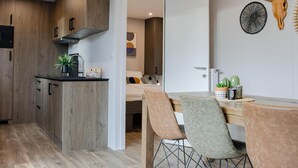 A modern kitchen with wooden cabinets, a black countertop, and a plant. - Colorado-inspired Cottage for 6 in Slagharen (Slagharen)