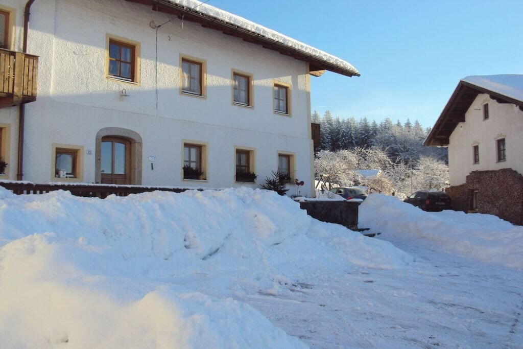 Un bâtiment à deux étages doté de nombreuses fenêtres, un sol recouvert de neige et un ciel dégagé.