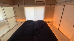 Une chambre avec un lit, une fenêtre et un appareil de climatisation.