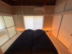 A room with a bed, a window, and an air conditioning unit. - Surrounded by forests and rivers, this whole-house rental offers a special getaway where you can enjoy camping, barbecues, and bonfires amidst nature. (富津市萩生)