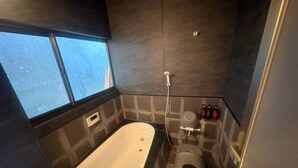 Une salle de bain avec une baignoire, des toilettes et une douche.