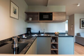 A modern kitchen with a built-in oven, a coffee maker, and a sink. - New, cozy apartment in a central location featuring Italian design and mountain views (Mühlbach)