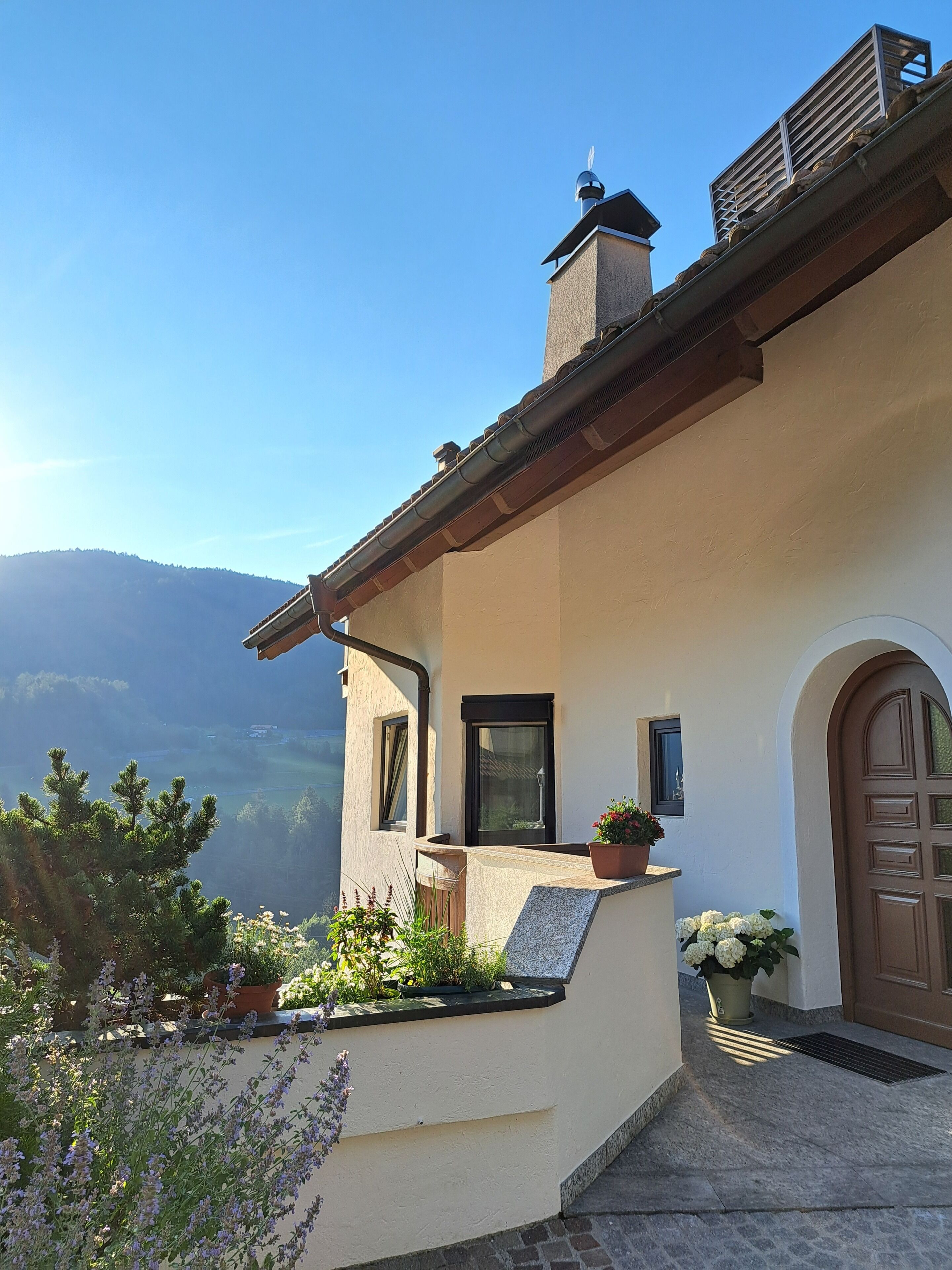 A house with a balcony, a chimney, and a door.